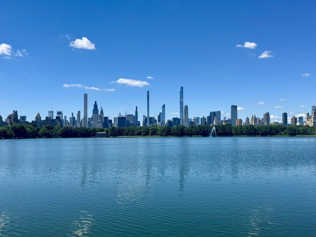 The reservoir in Central Park, New York, so big it looks like a massive lake, with a line of skyscrapers in the distance.