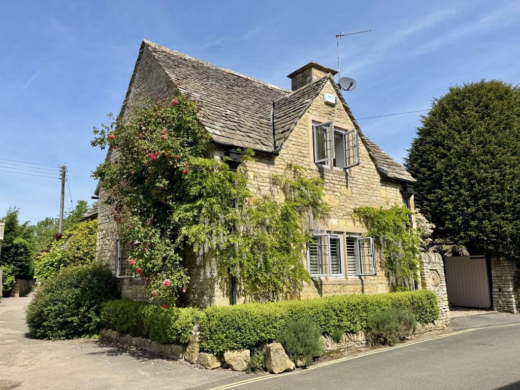 An adorable stone cottage covered with Ivy in the Cotswolds.