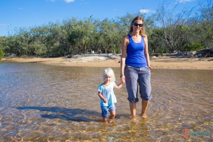 woman holding a girls hand in the water