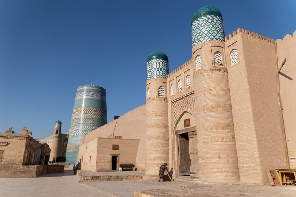 A tall sand-colored brick building topped with bright turquoise domes.