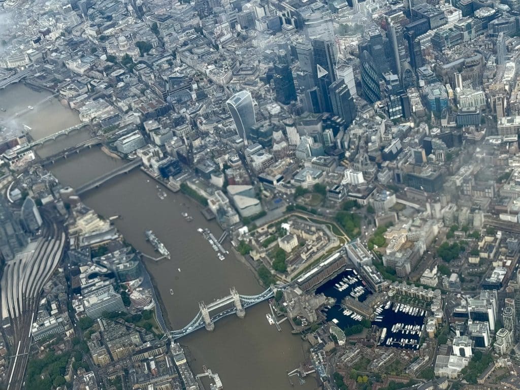 A view of London from a plane -- you can see the Tower Bridge and the Tower of London, along with skyscrapers.