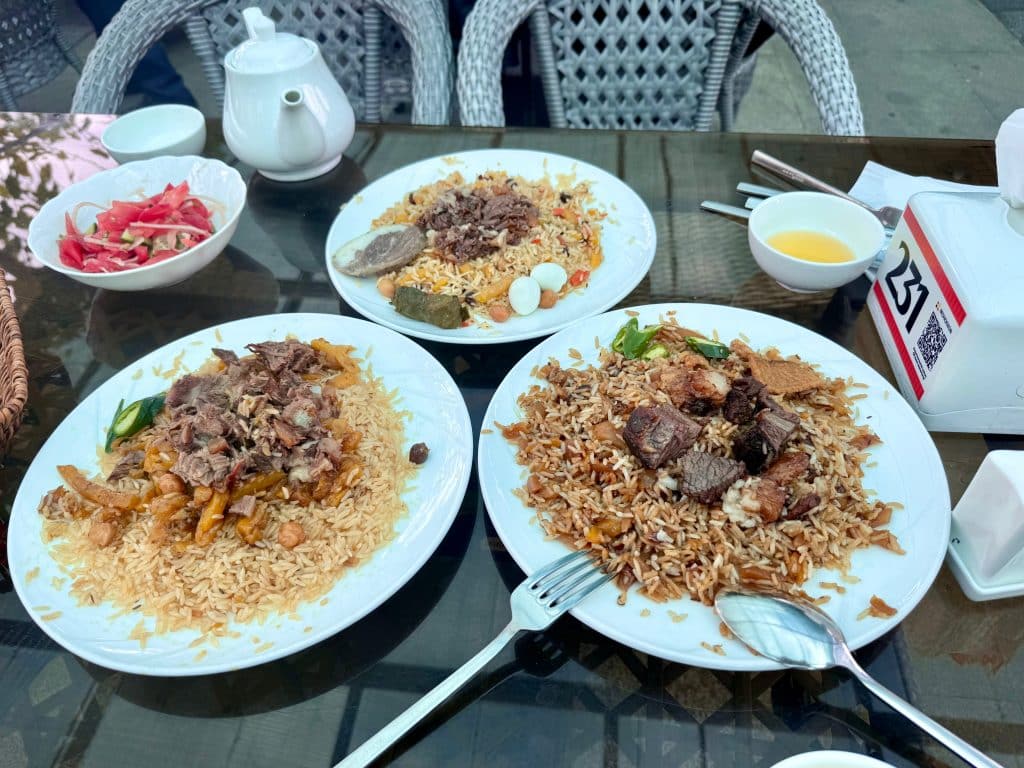 Three plates of different kinds of plov rice pilafs.