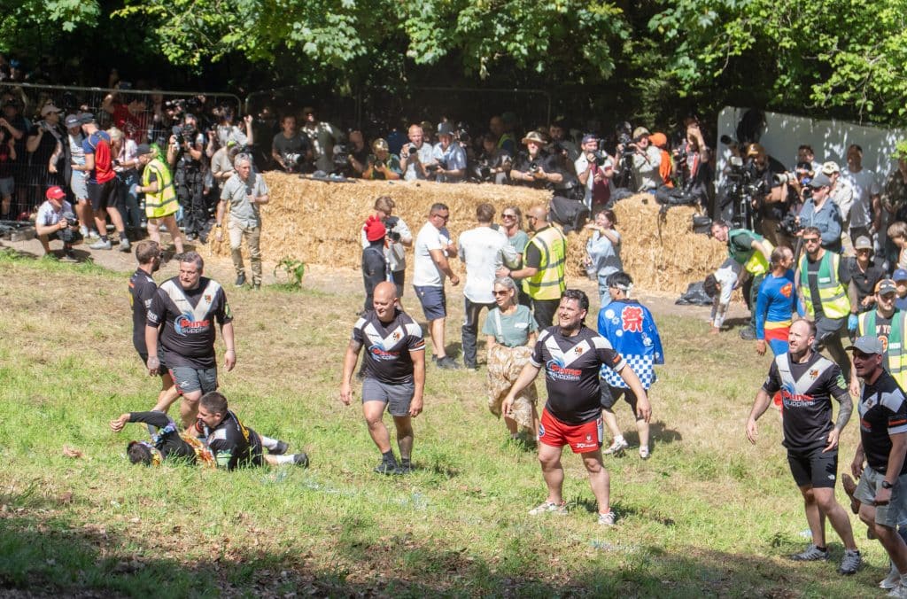 A line of rugby players at the finish line getting ready to catch everyone.