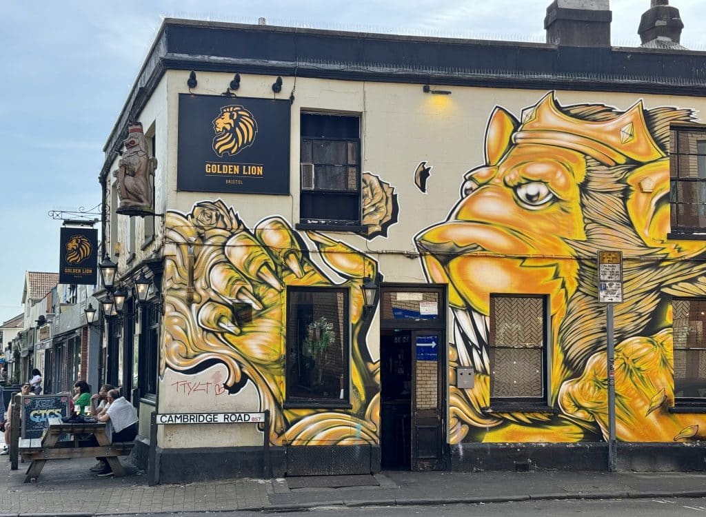 A pub covered with wild street art of a ferocious lion wearing a crown.
