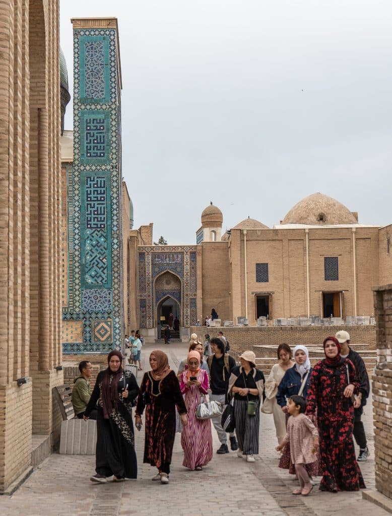 A group of Uzbek women wearing colorful local dress sightseeing at Shah-i-Zinda Mausoleum.