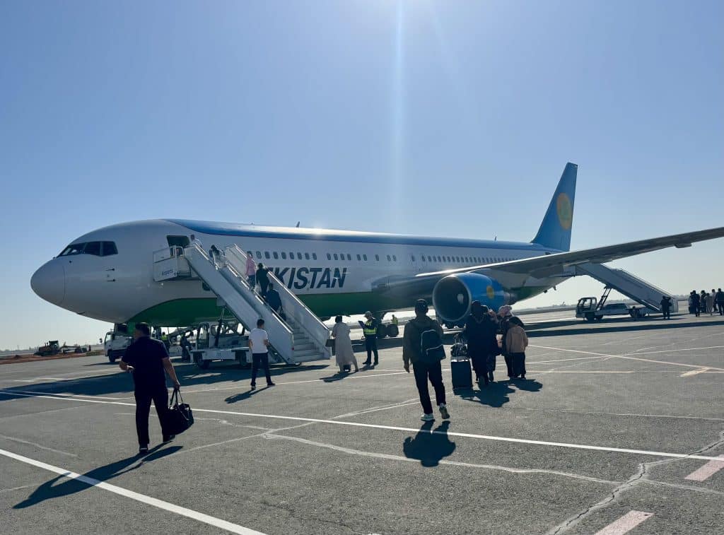 People boarding an Uzbekistan Airways airplane.