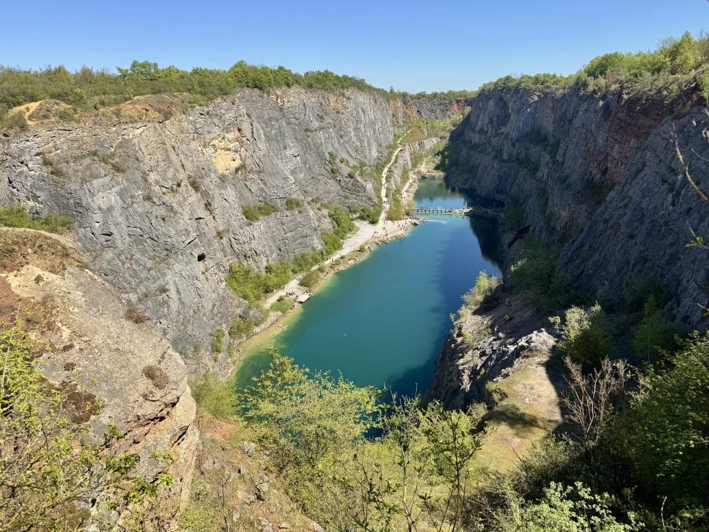 A big teal lake in the middle of a deep canyon.