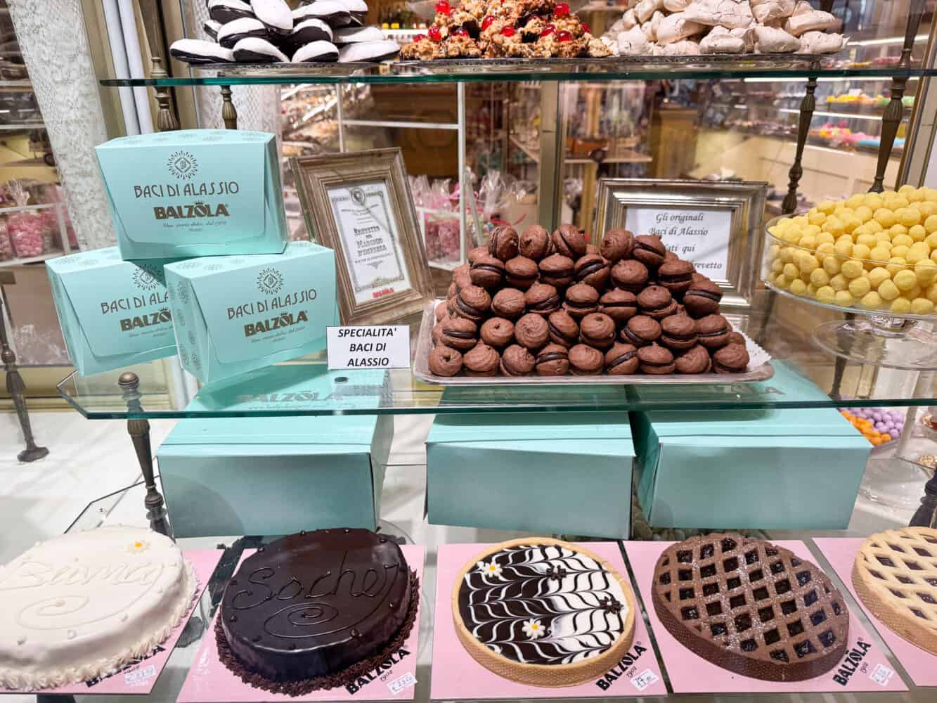 Baci di Alassio in the window of a cafe on Il Budello.
