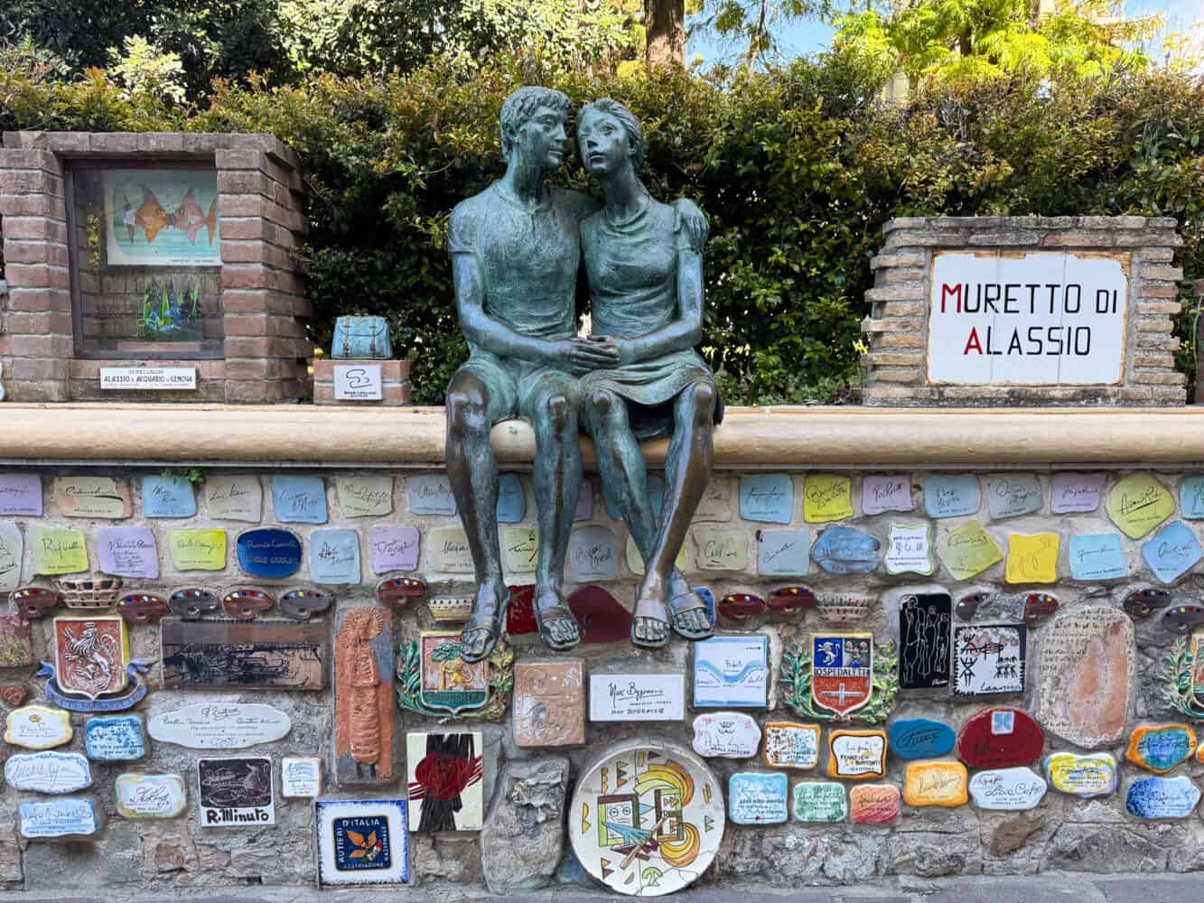 The Lovers sculpture and famous signatures on the Muretto di Alassio in Alassio, Italy. 