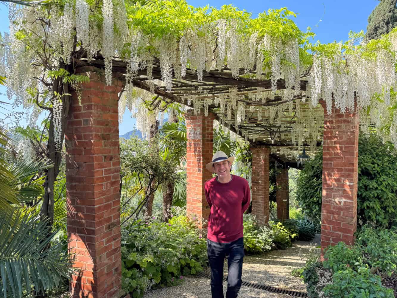 Simon walking under the white wisteria pergola at Villa della Pergola in Alassio, Italy.
