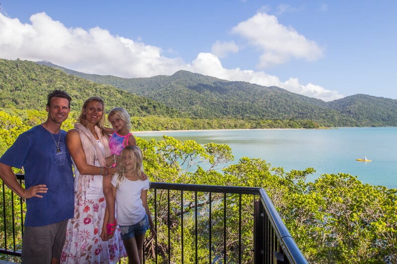 family posing with view of Cape Tribulation and Daintree Rainforest