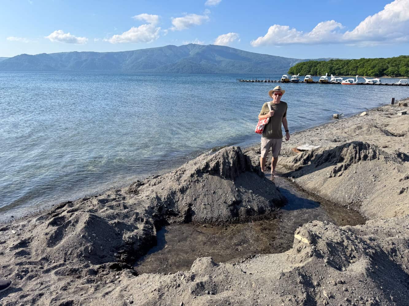 Simon standing in a natural footbath in the sand at Sunayu onsen, Lake Kussharo, Hokkaido.