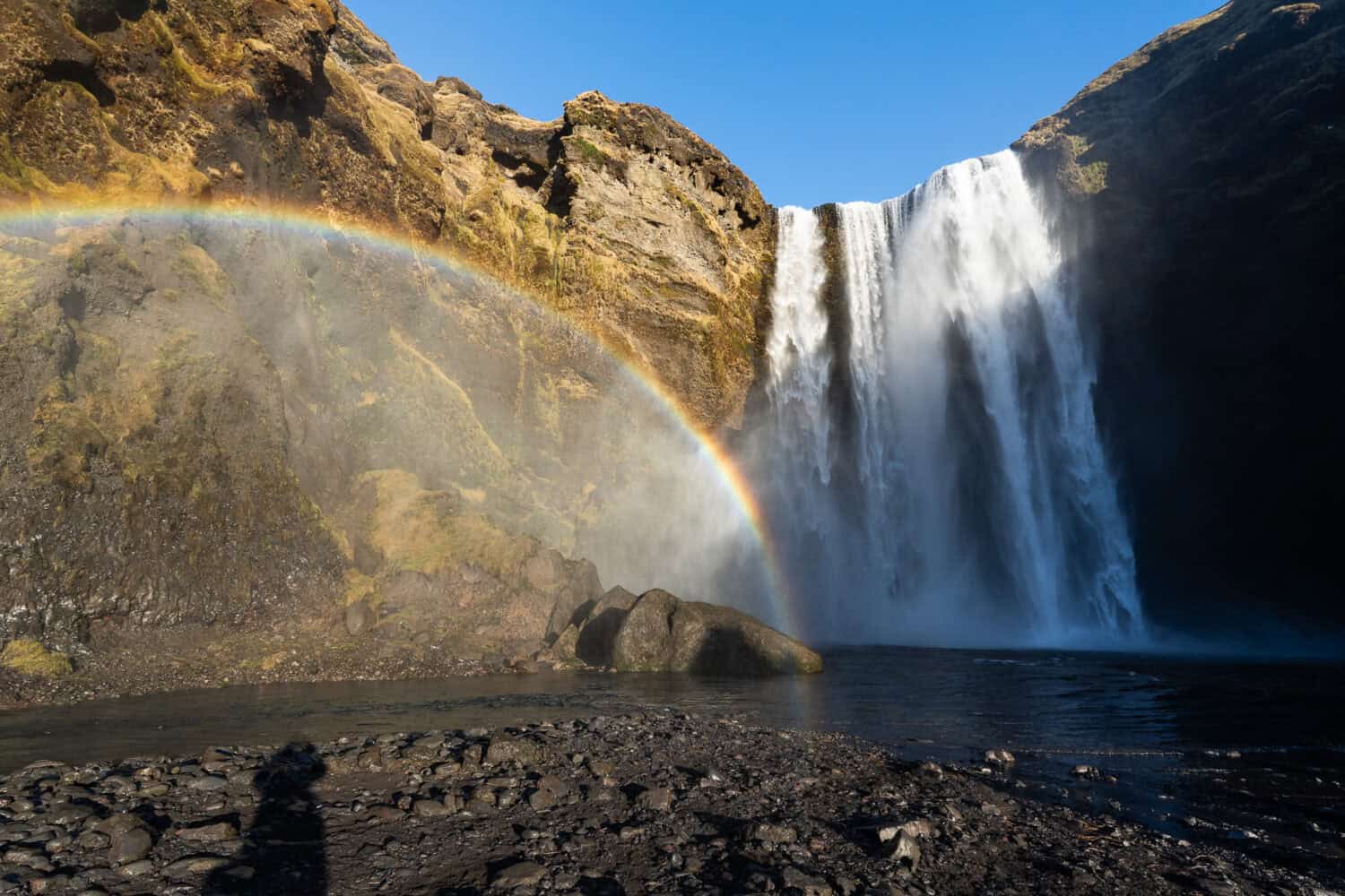 Rainbow at Skógafoss waterfall in South Iceland on a sunny day.