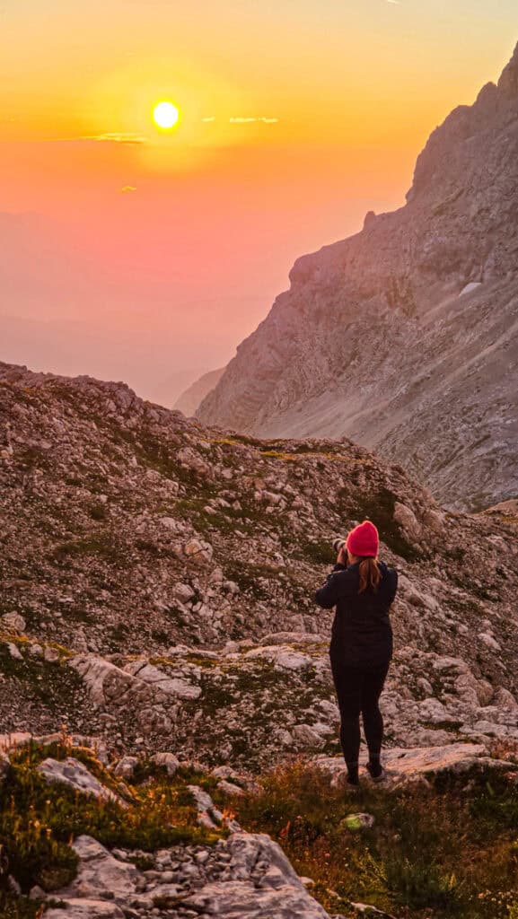 woman taking photo of sunrise at mount triglav