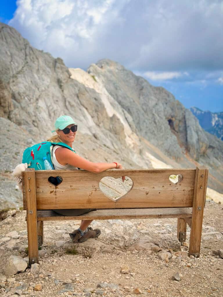 woman on bench on top of mt triglav looking at view