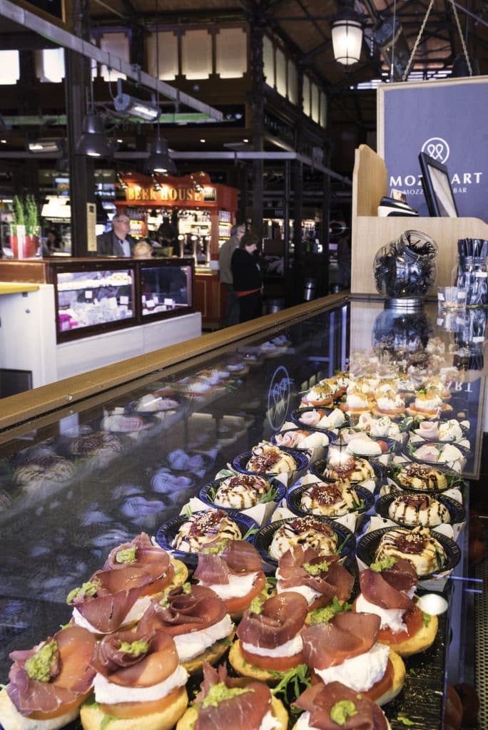 Interior of San Miguel Market showing a variety of fresh Spanish tapas and pinchos.