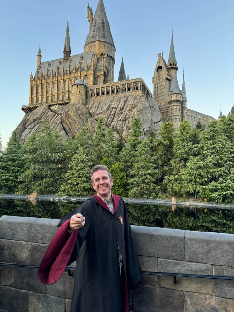 Simon with a wand and gown at Hogwarts Castle in Universal Studios Japan.
