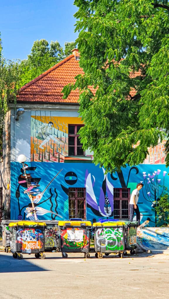 skateboarders and street art covered building of AKC Metelkova mesto