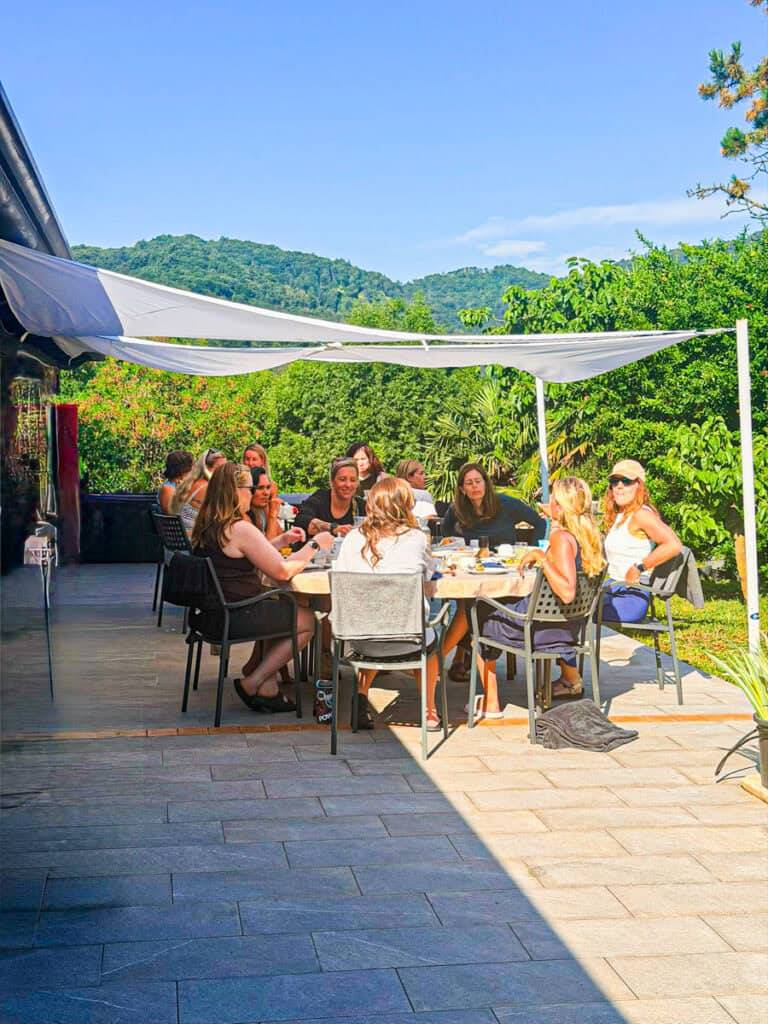 women enjoying breakfast at table outside
