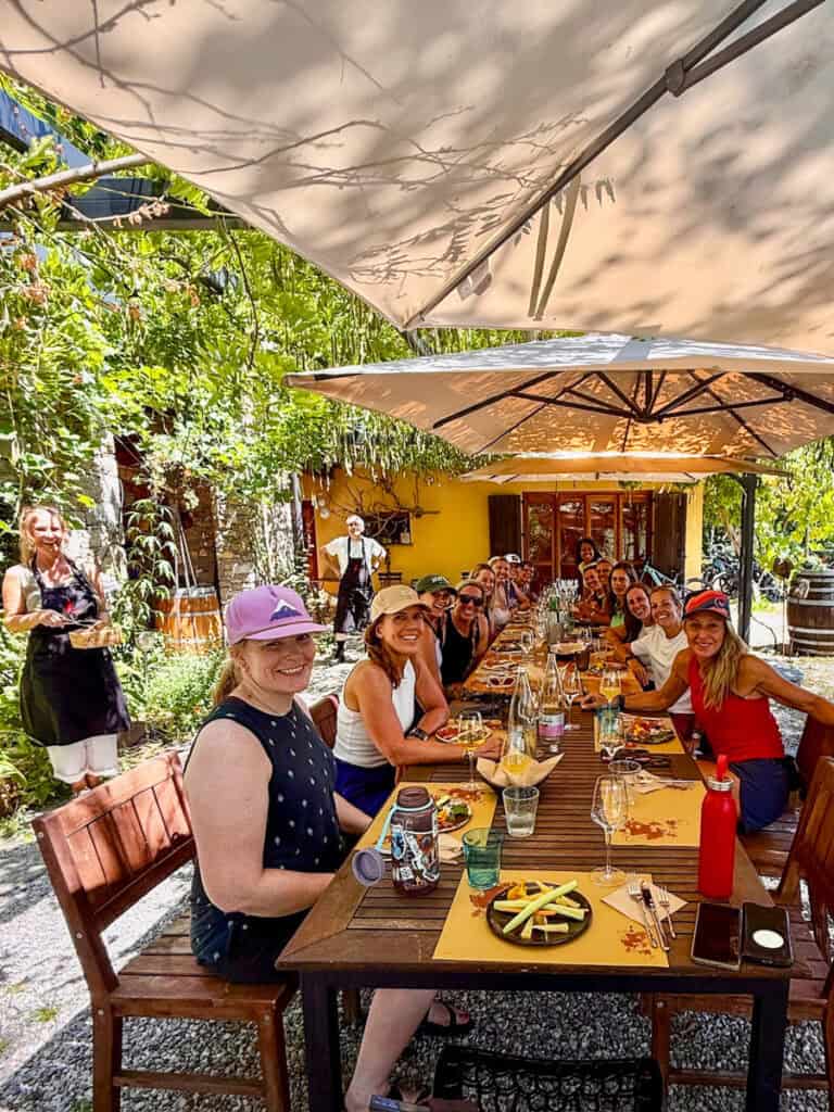 group of women sitting under umbrellas at outside table Atelier Kramar,