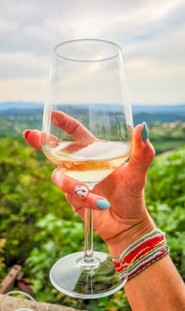 lady holding glass of rebula wine