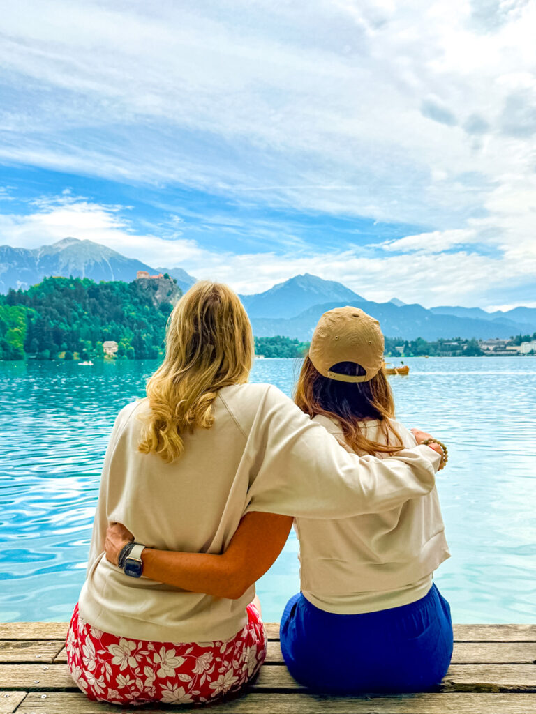 two girls hugging with lake bled view