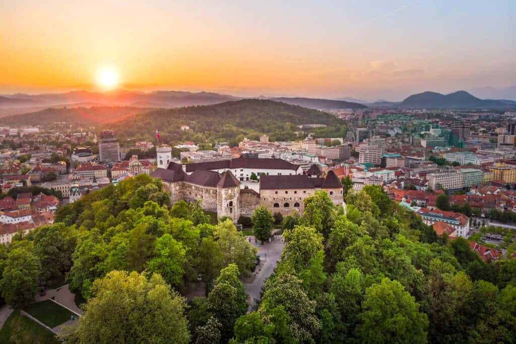 aerial sunset view overlooking ljublijana castle, the city and mountains in the background