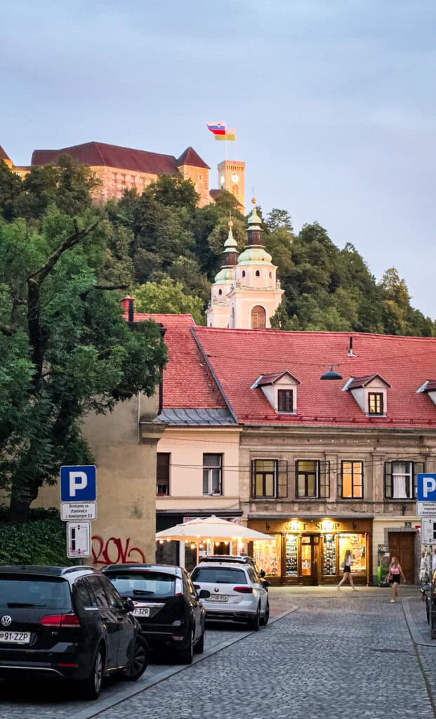view of ljubljana castle from streets of historic district at night