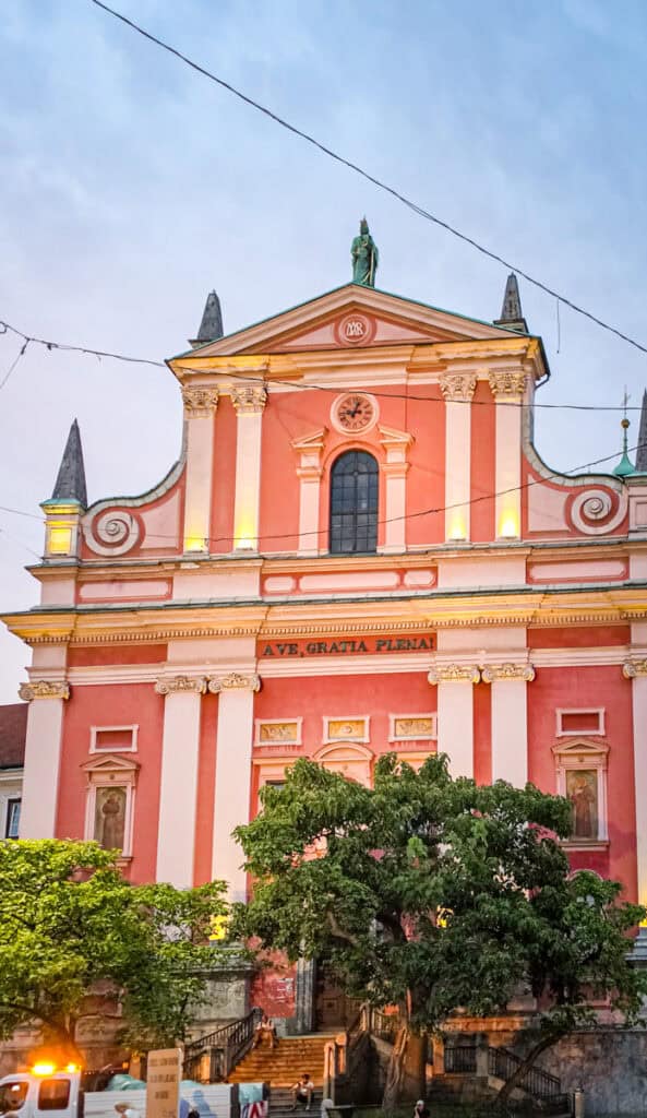 pink church lit up at night ljubljana