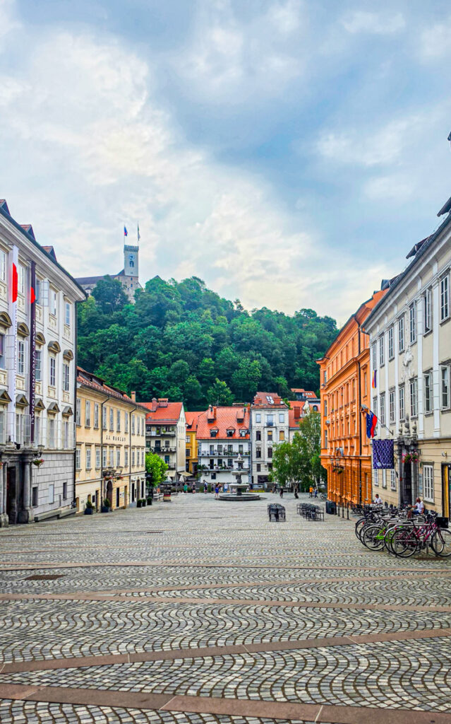 colorful street in ljubljana with castle on hill in background