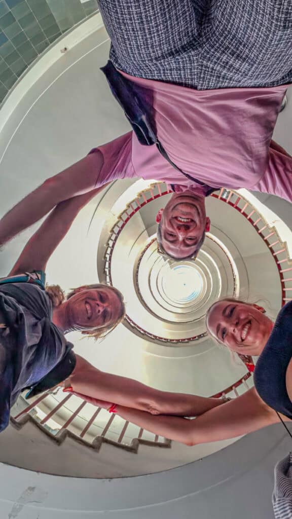 three people holding arms over staircase in p Nebotičnik