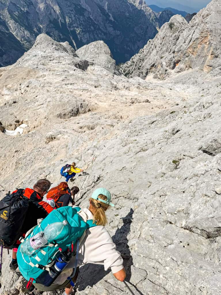 girls climbing down cliff using cables mt triglav