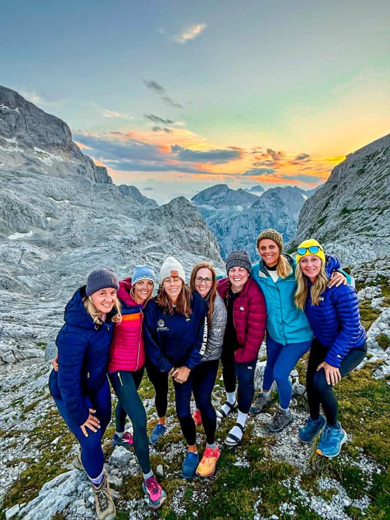 group of women hikers with sunset mt triglav