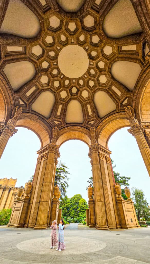 two girls standing under palace of fine arts rotunda