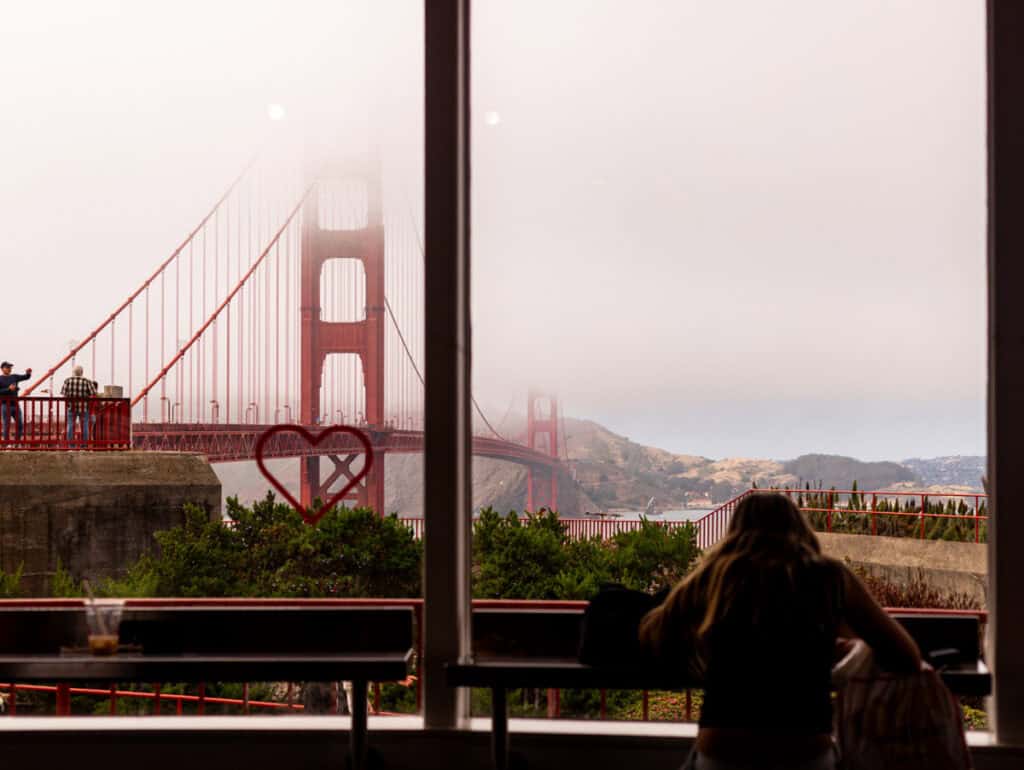 girl at roundhouse cafe with golden gate bridge views through the window