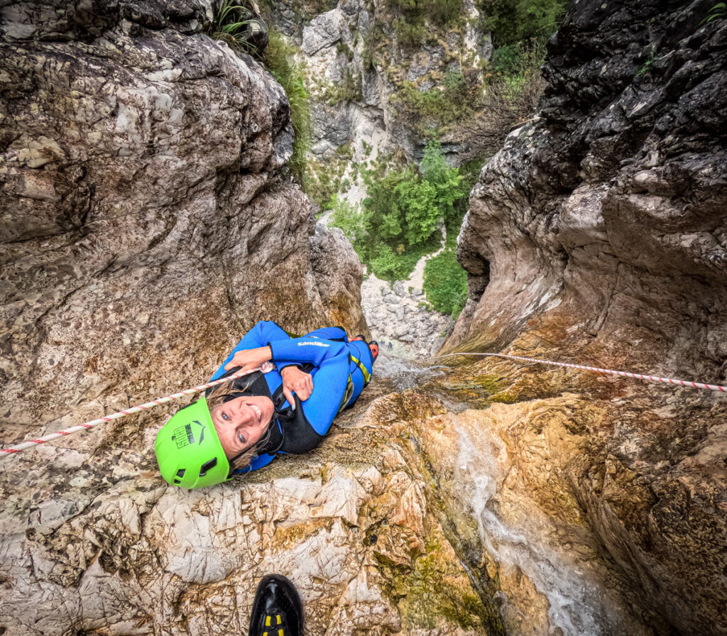 woman sliding down rock in canyon soca 