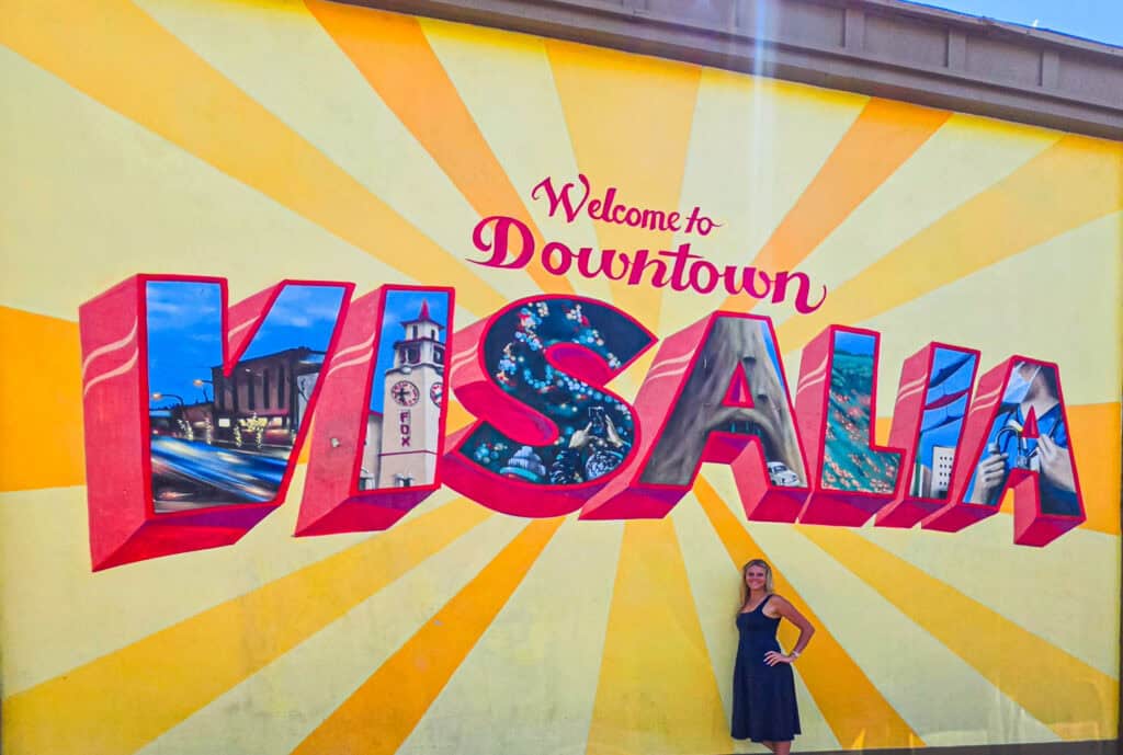 woman in front of visalia mural